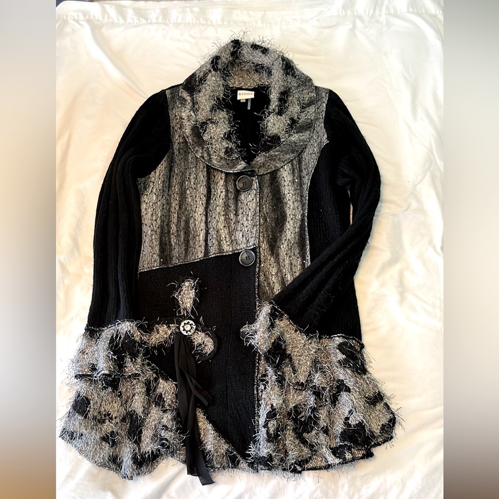 Just above the knee length dressy sweater, ruffled at bottom, big buttons.